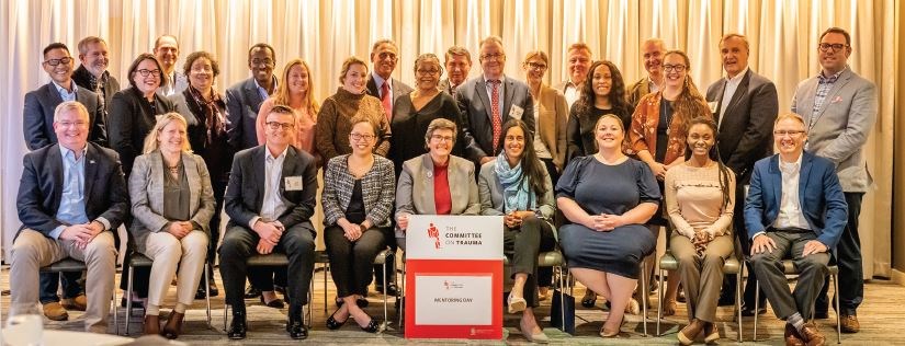 Mentoring Day participants, including Dr. Jacobs (back row, fourth from left), as well as coauthors of this article—Krista L. Kaups, MD, MSc, FACS (seated, second from left); Dr. Bulger (seated, holding sign); and Dr. Kerby (seated, third from left)