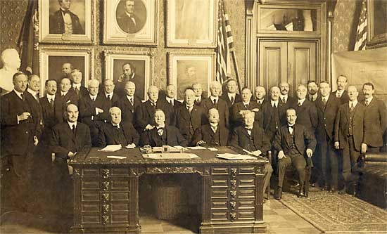 "The Organization of the Fosdick Commission." Seated: David F. Houston, Secretary of Agriculture; Franklin K. Lane, Secretary of Interior; Josephus Daniels, Secretary of the Navy; William C. Redfield, Secretary of Commerce; William B. Wilson, Secretary of Labor; Walter S. Gifford, Director, Council of National Defense and Advisory Commission Standing: Hollis Godfrey, MD; Irving Fisher, MD; Professor M.J. Rosenau; Howard Coffin; Bernard M. Baruch; Franklin H. Martin, MD; William A. Evans, MD; Daniel Willard; William Welch, MD; Julius Rosenwald; Samuel Gompers; Rear Admiral Wm. C. Braisted, USN; Major General Wm. C. Gorgas, USA; Surgeon-General; Rupert Blue, USPHS;Victor C. Vaughan, MD; Frank F. Simpson, MD; Abraham Flexner, MD; Brigadier General Jefferson R. Kean, Red Cross; Frederick A. Besley, MD; Alonzo E. Taylor, MD; Raymond B. Fosdick; Haven Emerson, MD; William F. Snow, MD; Theodore Janeway, MD <br>(Photo credit: Harris and Ewing, Washington, DC,1917. From the ACS Archives and published in The Joy of Living.)
