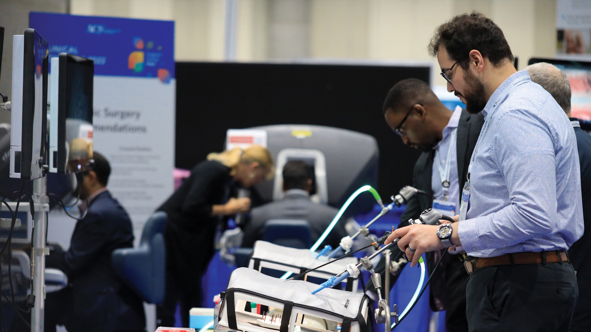 Two Clinical Congress attendees examine the laparoscopic  surgery station at the Surgical Ergonomics Clinic.